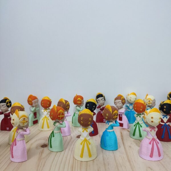 Grupo de muñecas Xiquetes Falleres en diferentes colores, con vestidos y peinados tradicionales falleros, representando la diversidad y la tradición valenciana.